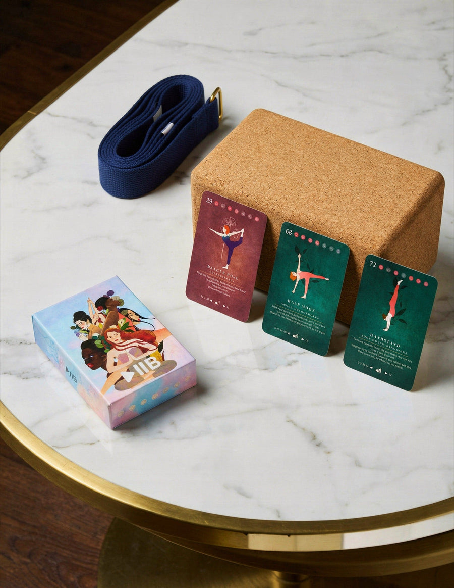 The PlayPauseBe Yoga Deck with three yoga cards, a cork block and a strap