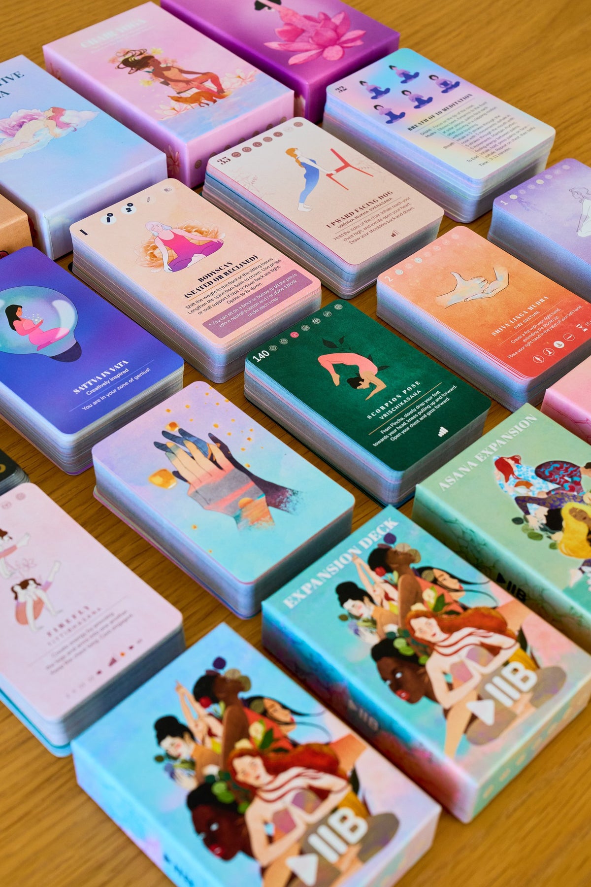 PlayPauseBe decks and cards laid out on a wooden table, showing the card stock and printed edges