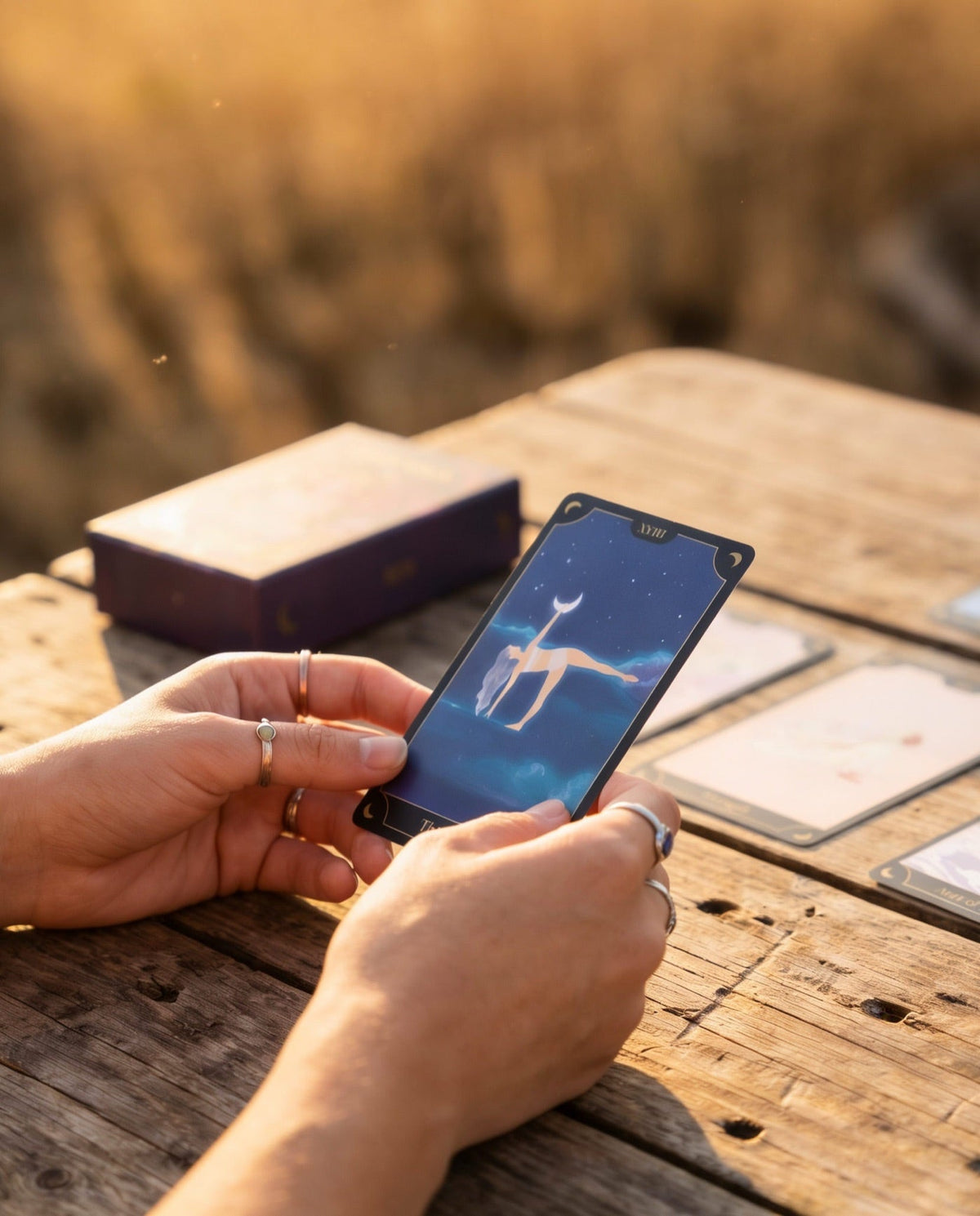 A Tarot Yoga Deck card held in the golden-hour light