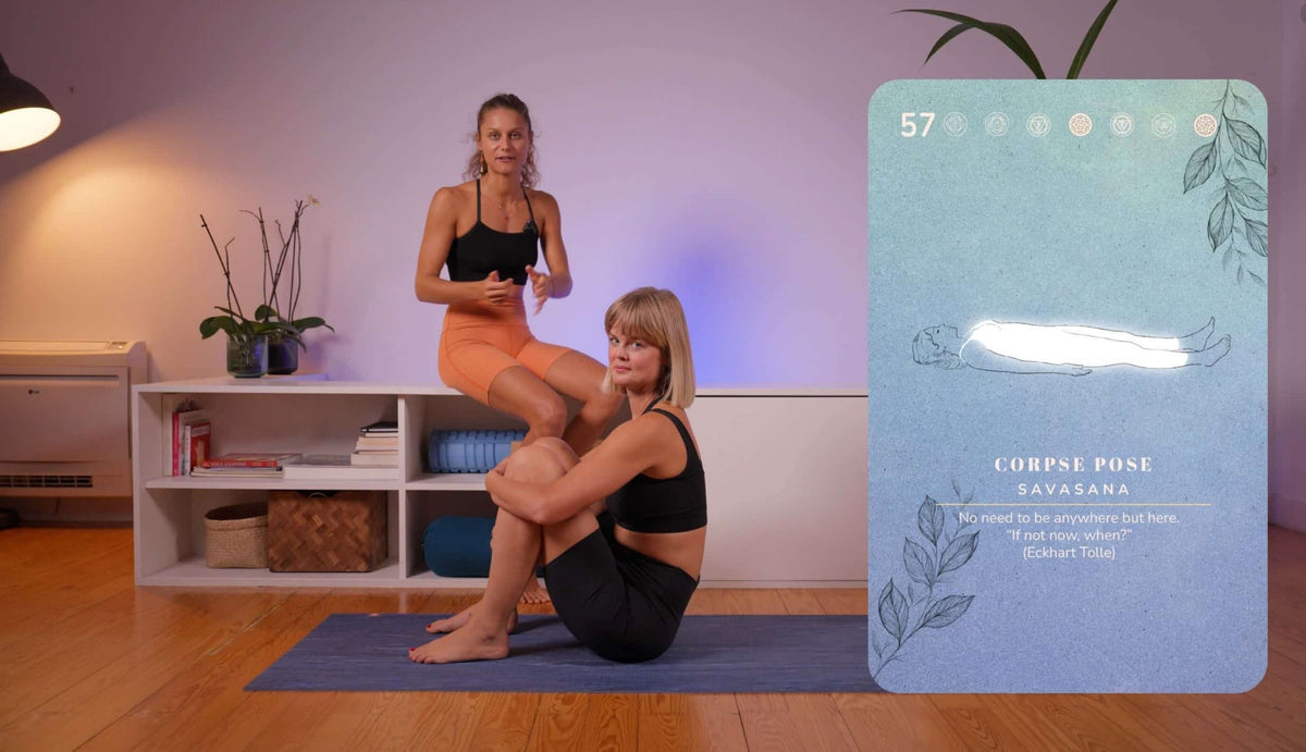 Illona and Tine in a Yin Academy lesson, next to the Corpse Pose card