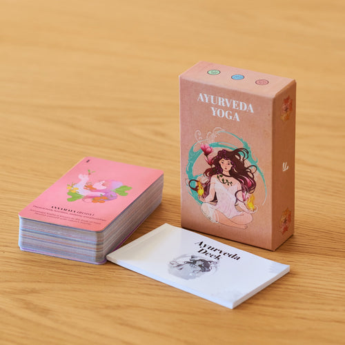 The Ayurveda Yoga Deck box with the card stack and the printed booklet on a wooden table